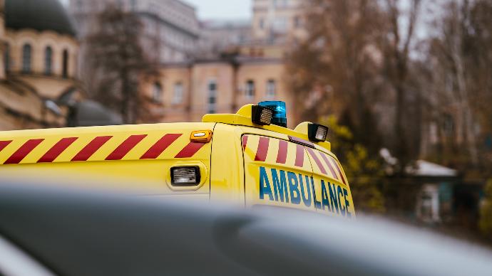 a yellow ambulance is parked in front of a building