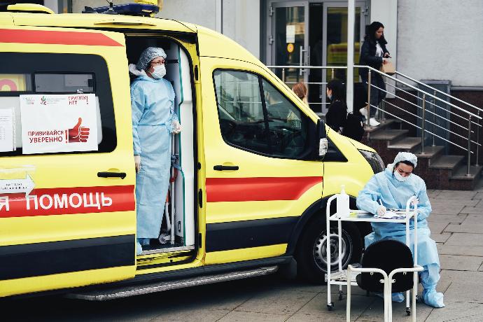 man in blue shirt sitting on yellow and red car
